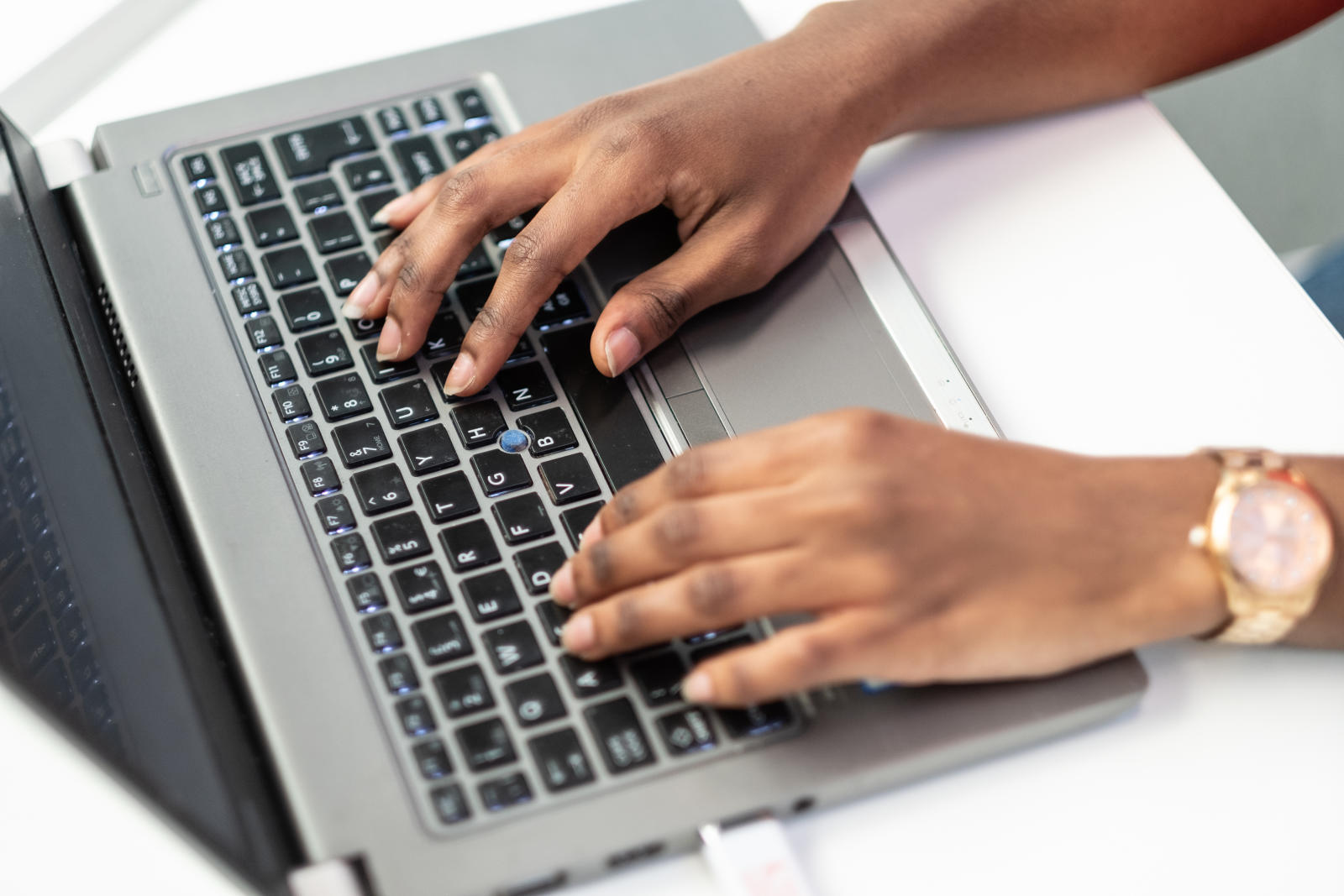 A member of staff typing on a laptop